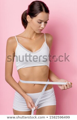 Zdjęcia stock: Woman Measuring Size Of Her Waist With A Tape Measure