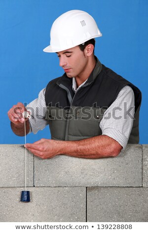 Foto stock: Mason Checking Wall Is Straight