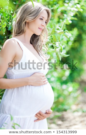 Stockfoto: Pregnant Woman Standing Apple Tree