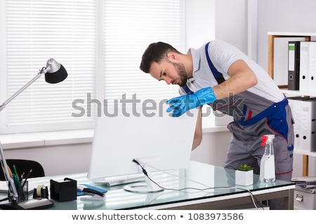 Foto stock: Young Male Janitor Cleaning Shelf