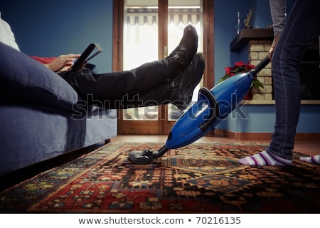 Foto d'archivio: Woman With Tablet Pc And Vacuum Cleaner At Home