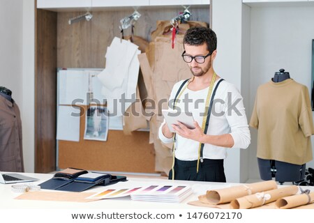 Young Tailor In Casualwear Surfing Through Websites Of Fashion Trends Сток-фото © Pressmaster