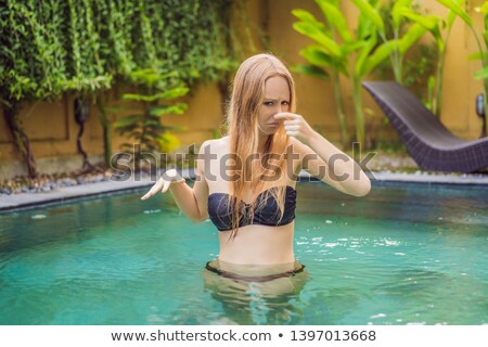 Foto d'archivio: Young Woman With Disgust On His Face Pinches Nose Something Stinks Very Bad Smell In Swimming Pool