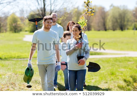 Сток-фото: Group Of Volunteers With Trees And Rake In Park