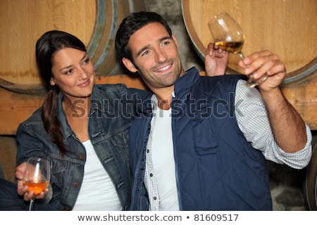 Stockfoto: Smiling Man And Woman Tasting Wine In A Cellar