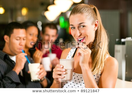 Stock foto: In · junges · Paar, · das · Milchshakes · in · einem · Cafe · trinkt