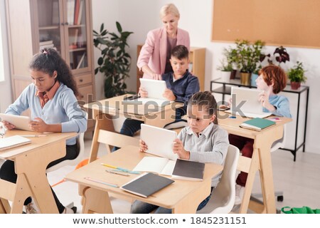 ストックフォト: Young Serious Schoolgirl And Her Classmates Working Individually