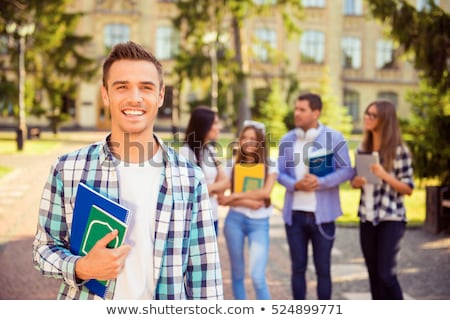 Stock foto: Male Student With Group Of Classmates On Background Working At T