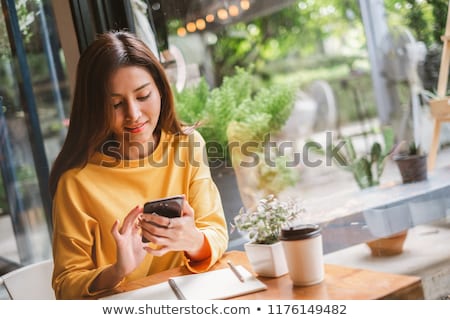 Сток-фото: Young Blogger Woman Using Phone In Cafe