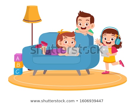 Stock photo: Boy Uses A Tablet At Home On The Couch In The Background Of A Window With Skyscrapers Modern Childr