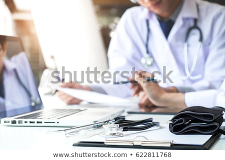 Stock fotó: Doctors Being Discussing Patient History In An Office Pointing T