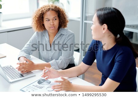 Foto d'archivio: Young Serious Mixed Race Accountant Looking At Her Colleague Explanation