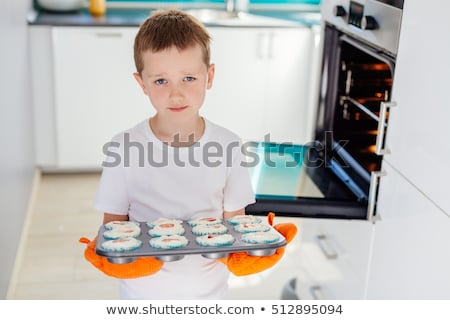 Stockfoto: Boy Holding A Tray Of Muffins At Home