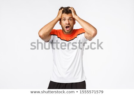 Foto stock: Nervous Shocked Handsome Sportsman Feel Anxious Grab Head In Panic Gasping Open Mouth And Stare