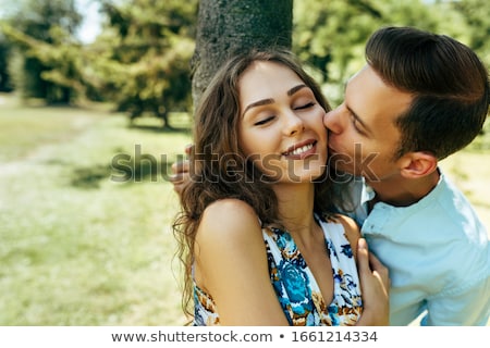 Foto stock: Boyfriend Kisses Girlfriend On Cheek In Sunny Nature