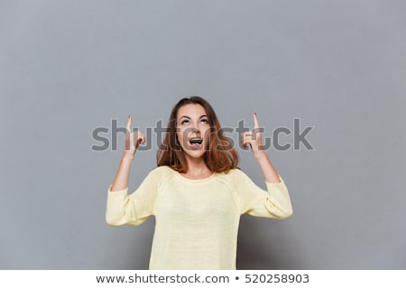 Stok fotoğraf: Portrait Of A Happy Excited Woman Pointing Two Fingers Up