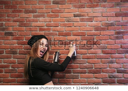 Stock fotó: Image Of Stylish Hip Hop Girl 20s Drawing On Brick Wall With Sp