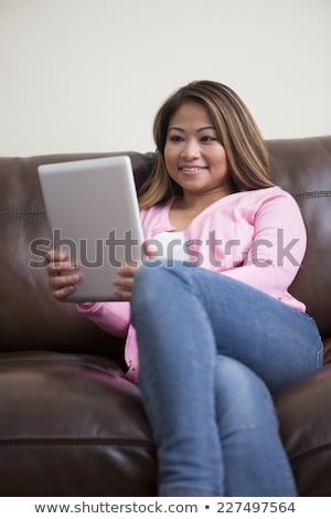 [[stock_photo]]: Attractive Woman Sitting On The Floor Reading In Her Home