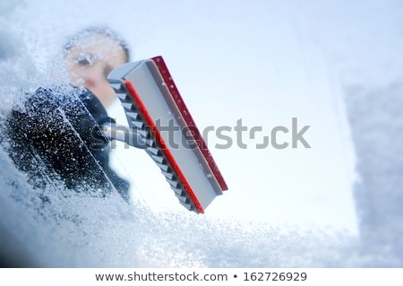 Foto d'archivio: Hand With Glove Scratching Ice From Windshield