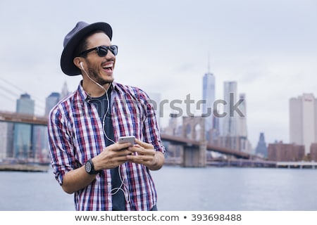 Zdjęcia stock: Happy Attractive Young Man Listening To Music From Smartphone