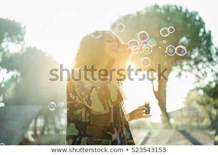 [[stock_photo]]: Young Afro Hair Woman Blowing Soap Bubble In City Skate Park Wit