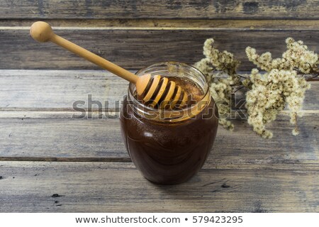 Foto d'archivio: Pouring Honey On The Dark Wooden Background