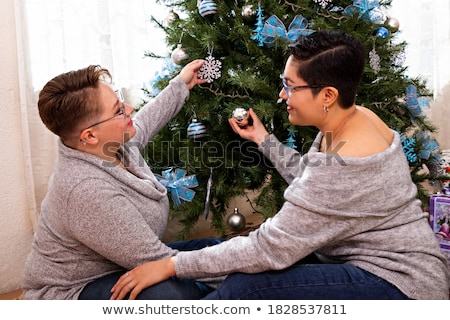 Foto stock: Young Couple Decorating Fir Tree For Christmas Eve