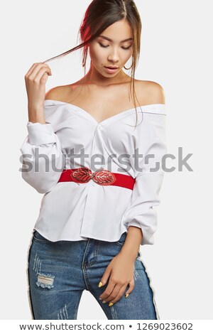 Stock photo: Woman Holding Her Shoulder While Looking Down And Wearing A Red Dress