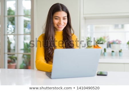 Stock photo: Portrait Of A Beautiful Young Woman Sitting At The Table