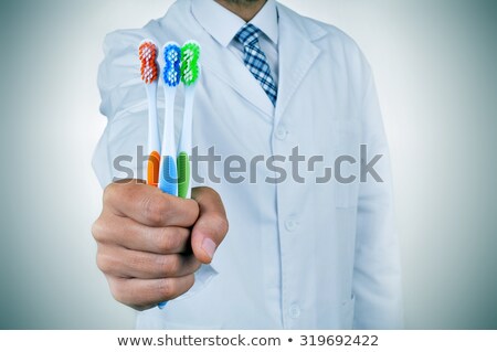 A Dentist Man Showing Some Toothbrushes Foto stock © nito