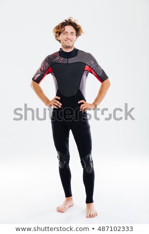 Zdjęcia stock: Happy Joyful Sportsman In Diving Suit Holding Arms On Hips