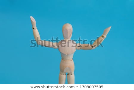 Foto d'archivio: Wooden Figurine Standing With Hand Raised