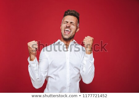 ストックフォト: Photo Of Optimistic Man In Formal Wear Shouting And Clenching Fi