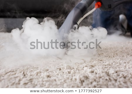 Foto stock: Housekeeper Cleaning Carpet With Vacuum Cleaner