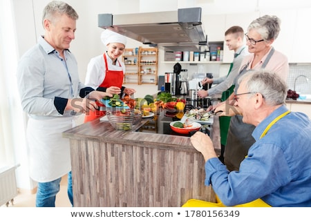 Foto stock: Chef Showing Trainees The Secrets Of Healthy Cooking In Her Kitchen