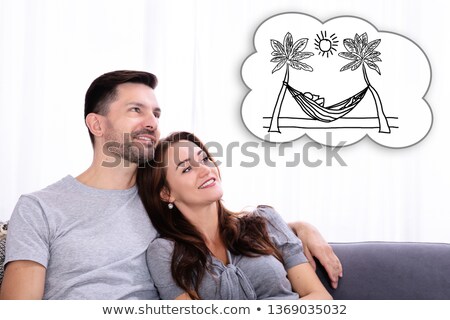 Stockfoto: Thinking Of Having Vacation Together While Sitting On Sofa