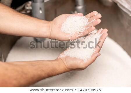 Human Hands Holding Two Piles Of White Polymer Granules Stockfoto © Pressmaster