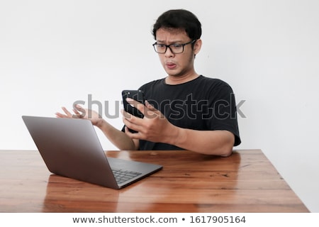 Stok fotoğraf: Wow Face Of Young Asian Man Shocked What He See In The Laptop When Working Isolated Grey Background