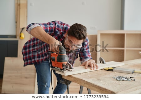 Stock photo: Carpenter Sawing Wood