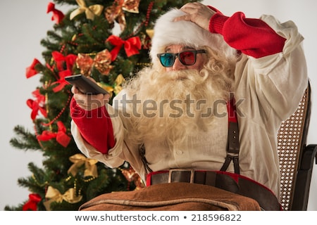 Zdjęcia stock: Santa Claus Sitting In A Comfortable Rocking Chair Near The Chri