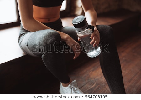 Foto stock: Studio Shot Of Exercising Woman Drinking Water