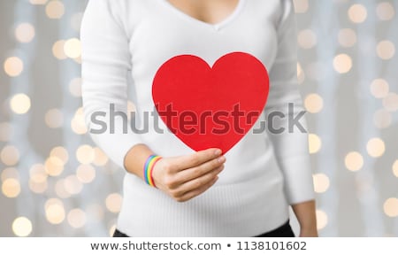 Stok fotoğraf: Woman With Gay Awareness Wristband Holding Heart