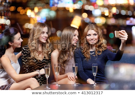 Stockfoto: Woman Picturing Friends By Smartphone At Wine Bar