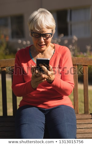 Foto stock: Front View Of An Active Senior Caucasian Woman Using Mobile Phone In The Park