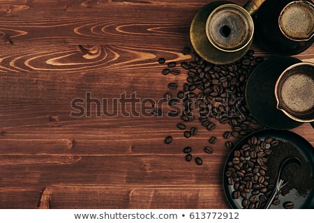Stok fotoğraf: Hot Coffee In Shabby Turkish Pots Cezve With Beans Saucer With Copy Space On Brown Old Wooden Board