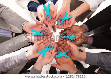 [[stock_photo]]: Group Of Businesspeople Holding Teal Ribbons