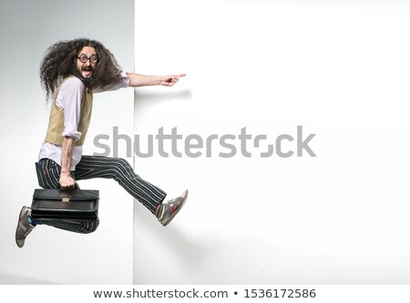 Stok fotoğraf: Portrait Of A Nerd Jumping Next To The White Empty Board