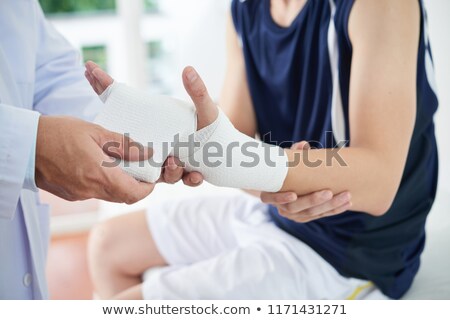 Foto stock: A Doctor Wrapping A Wounded Wrist