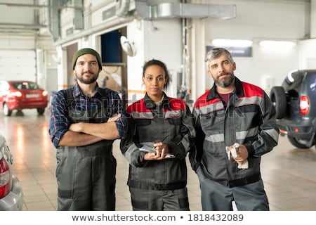 Three Workers In A Garage Portrait Stockfoto © Pressmaster
