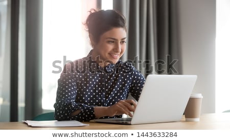 Stock fotó: Beautiful Young Girl Is Sitting At The Table In The Office